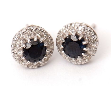 Pair of sapphire and diamond cluster earrings, the round faceted sapphires claw set to a surround of 12 small diamonds, to an