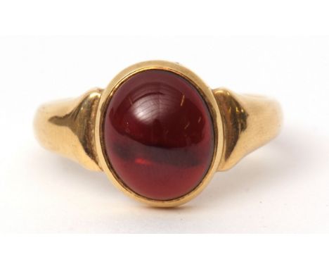 18c stamped garnet ring, the oval cabochon garnet set in a plain polished rub-over mount, size U 