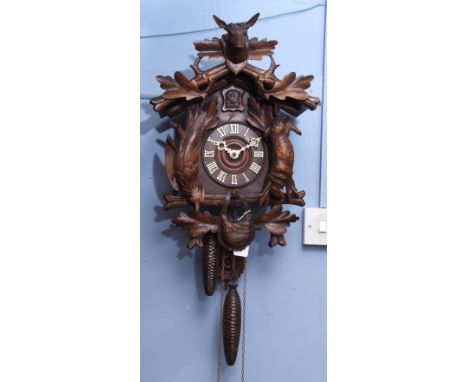 Late 19th century "Black Forest" wall mounting cuckoo clock, the architectural case with a detachable pediment carved with le