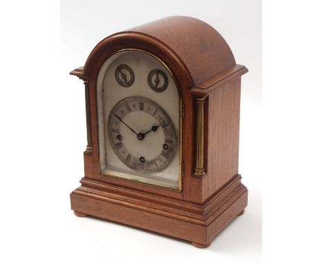 Early 20th century oak cased triple barrel mantel clock, the arched case with overhanging cornice with lacquered brass fluted