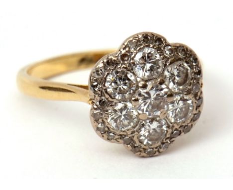 Diamond cluster ring, the circular shaped panel with seven brilliant cut diamonds within a small diamond surround, stamped 18