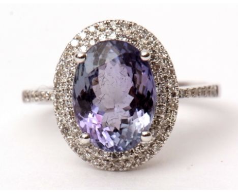 Precious metal tanzanite and diamond ring, the oval cut tanzanite 3.57ct approx, raised within a diamond surround, basket set