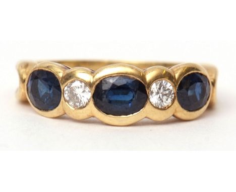 18ct gold sapphire and diamond ring, featuring three oval shaped faceted sapphires and two brilliant cut diamonds all in rub-