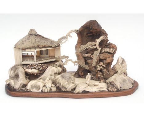 Intricate Japanese diorama depicting a mountainous landscape with pavilions and figures in wood, antler, ivory and bone on or