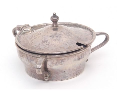 George V Arts &amp; Crafts spot hammered lidded mustard of circular form with three scrolled handles with domed cover and cas