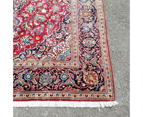 Kashan red grounded rug with dark blue border and pale blue detail to the central medallion 293cm x 198cm