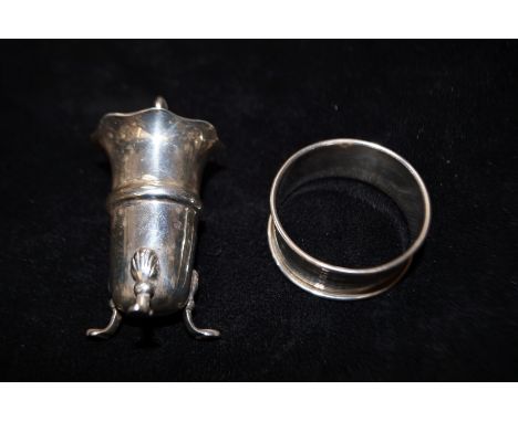 Silver pepper pot on paw feet together with a silver engine turned napkin ring