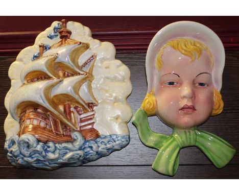 BESWICK FIGURAL WALL PLAQUE
modelled as a female head wearing a bonnet, 24cm long ;together with a 1930s Beswick wall plaque 