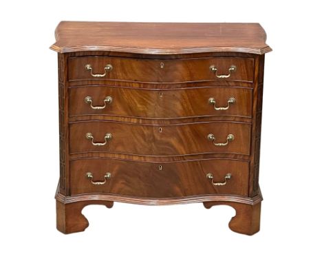 An Early 20th Century Chippendale Revival mahogany serpentine front chest of drawers on bracket feet and closed fret canted c