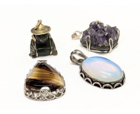 A quantity of pendants, including 1 jade pendant, a silver bound pendant, with 2 others.