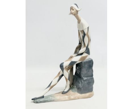 A large NAO seated harlequin jester figurine. 26x37cm