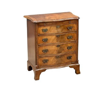 An Early 20th Century Chippendale Revival mahogany serpentine front chest of drawers, with brushing slide and closed fret cor