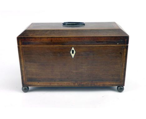 A Regency rosewood tea caddy with tulipwood banding, boxwood stringing and an ivory diamond escutcheon on brass ball feet. h.