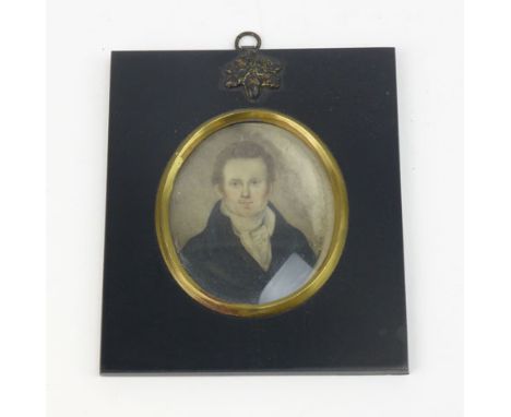A 19th century miniature oil on ivory portrait depicting a gentleman in a black caot within a gilt metal mounted and ebonised