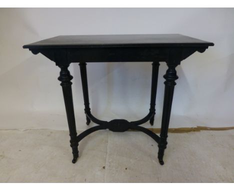 A late Victorian ebonized aesthetic movement side table, the moulded top on turned and reeded legs joined by curved x stretch