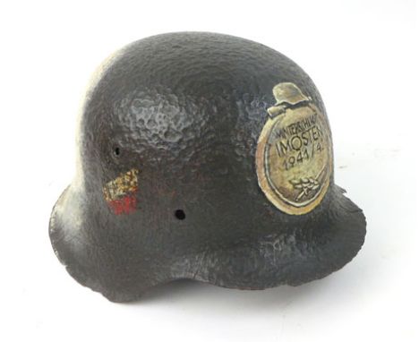 A Second World War Nazi German helmet with painted decoration to front and back marked 'Winterschlacht im Osten 1941/1942' (t