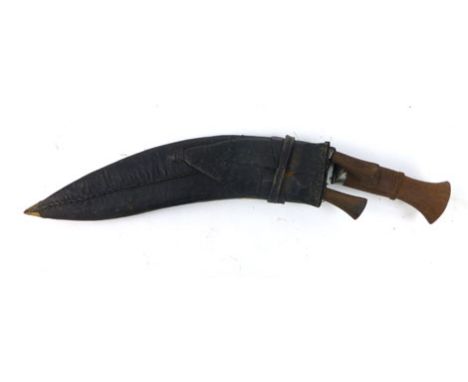 A 20th century Kukri knife with hard wood handle in a plain leather scabbard, blade l. 27 cm, with two smaller blades