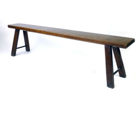 A 19th century elm pig bench with exposed tenons and fox wedges, on four splayed legs with two plain strechers, h. 50 cm, l. 