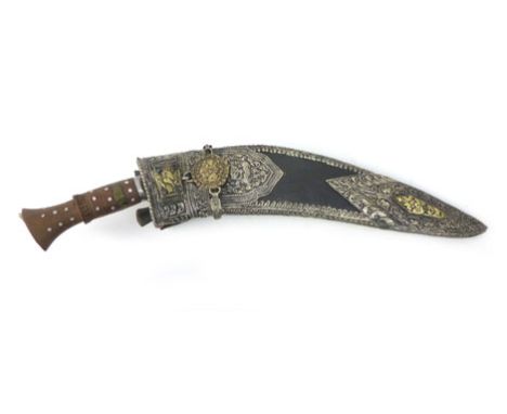 A 20th century Kukri knife with brass and metal engraved handle, leather scabbard with white metal decoration incorporating s