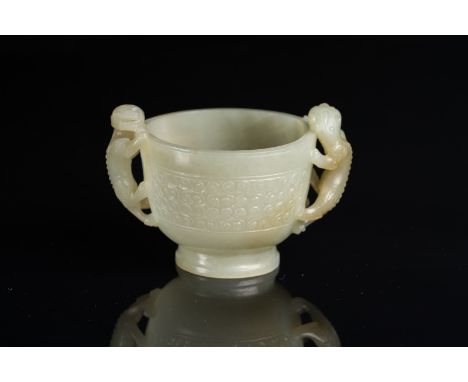  A pale jade cup decorated with archaic millet seed patterns and chilong handles  China, Qing dynasty, 19th century . Cm 8,00