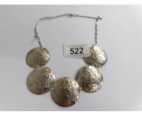A textured solid silver necklace as round discs.
