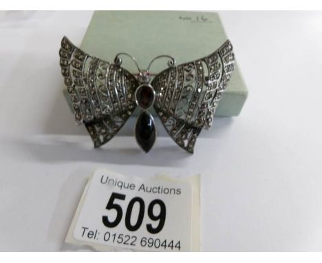 A superb dragonfly brooch set to body with oval garnet and onyx in marcasite and silver.