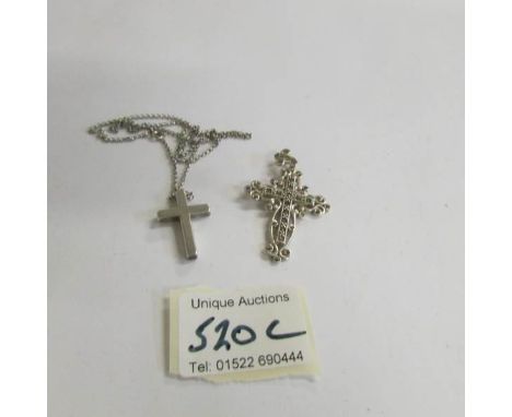 A silver cross on chain and a silver marcasite cross.