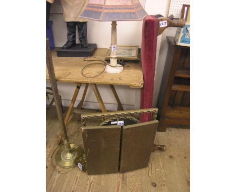 A long upholstered footstool, brass floor lamp, marble table lamp, three brass fire-irons and a folding gilt dressing mirror
