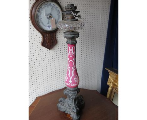 A good late Victorian oil lamp, bulbous-pink glass stem painted with flowers in white enamel, cut clear glass reservoir, on c