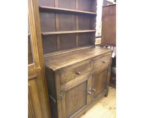 A dark oak dresser, three-shelf plate rack above panelled cupboard base with two drawers, 3ft. 6in.
