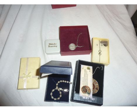 Collection of silver jewellery, including St. Christopher necklace, scimitar pin and white metal ammonite fossil necklace. UK