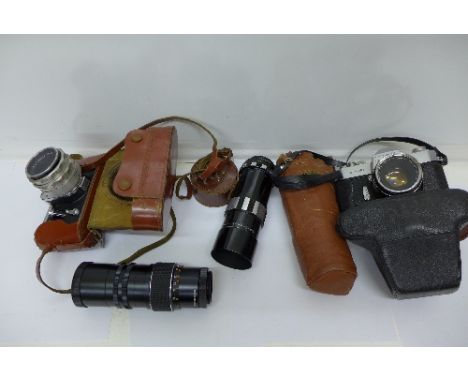 A Pentagon F camera and a Yashica TL-Super camera, both with lenses and two additional telephoto lenses