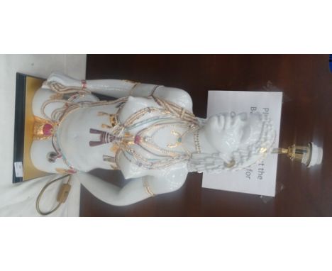 An Italian white porcelain figural lamp base, modelled as an African woman, highlighted in gold