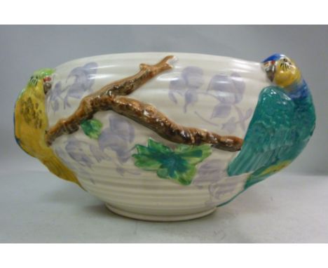 A Clarice Cliff ribbed, cream coloured glazed pottery fruit bowl of bulbous form, decorated in colours with moulded parrots, 