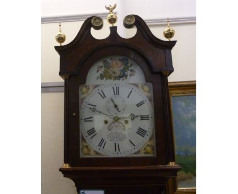 An early 19thC oak longcase clock, the hood having a swan neck pediment and three spherical brass finials, over an arched doo