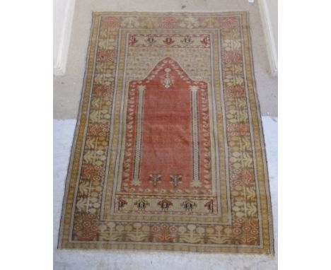 A Ghiordes prayer rug with a mirab on a red ground within a seven section plant motif border  68'' x 48'' 