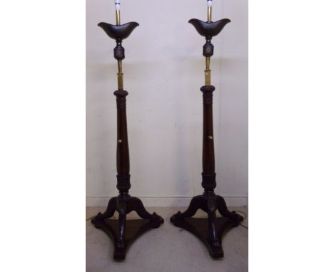 A pair of William IV mahogany lamp standards, each having a patinated, navette shaped metal reservoir, set on a lacquered bra