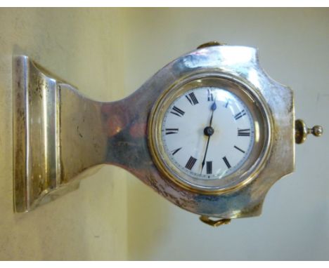 A silver angular pedestal vase shaped cased mantel timepiece, having a turned finial and flank ring handles; the movement fac