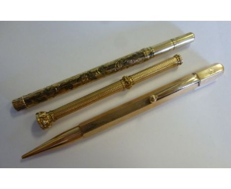 Three early 20thC gilt gold filled metal cased propelling pencils, viz. a Butler & Co of London with a seal terminal; another