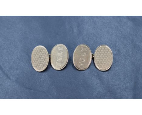 A pair of 9ct gold cufflinks having engine turned decoration and monograms to oval panels with chain connectors, approx 5.9g