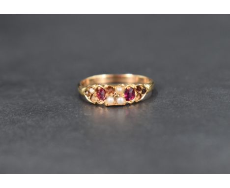A seed pearl and ruby ring, the four central square set seed pearls flanked by two oval cut rubies followed by a further thre