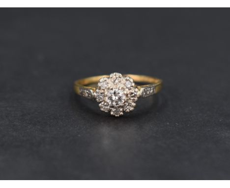 A diamond cluster ring, the central round brilliant cut diamond measuring approximately 0.20ct with an eight diamond surround