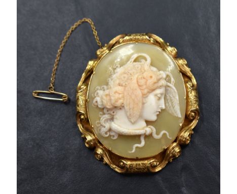 An excellent shell cameo brooch depicting the profile of Medusa adorned with serpents and wings, in a (tested) high carat gol