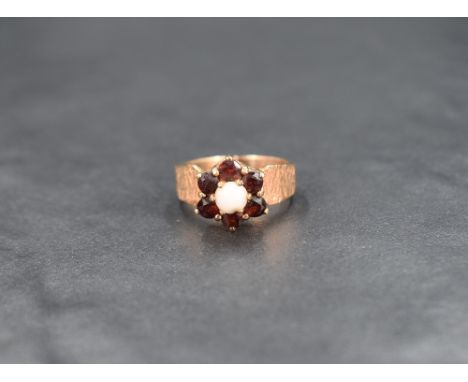 A garnet and opal cluster ring having a claw set raised mount on a 9ct gold bark effect loop, size L &amp; approx 4.3g