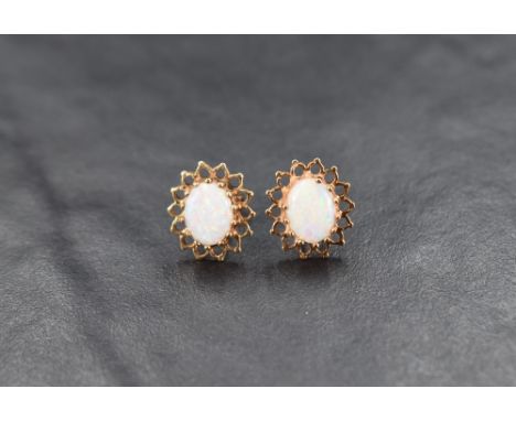 A pair of 9ct gold opal stud earrings, the opal cabochons set in a pierced halo setting, 2.2g