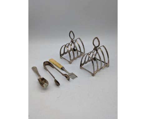 A pair of silver toast racks, hallmarked Birmingham, H.11cm, together silver a silver scoop, silver tongs and silver fork, 16