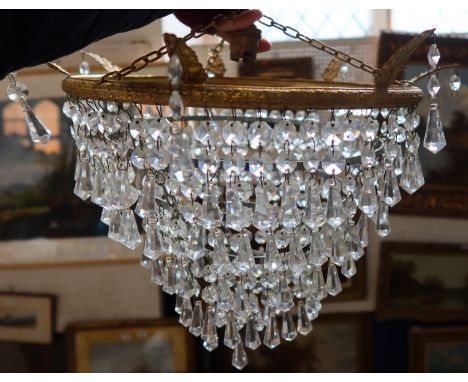 A three tiered light shade, with glass droppers, together with a glass candle holder