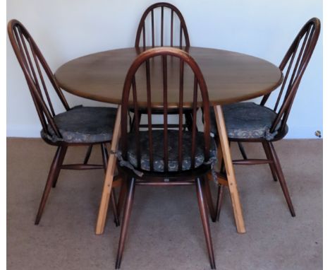 Ercol mid 20th century oak drop leaf dining table with four stick back chairs. Tbale Approx. 70 x 113 x 124cms

used with wea