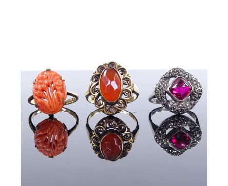 A 14ct gold carnelian dress ring, size M, a 9ct carved coral panel ring, size M, and a silver cabochon ruby and marcasite rin