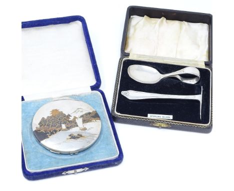 An Oriental sterling silver and enamel compact, with lake scene lid, diameter 8.5cm, boxed, together with a cased silver baby